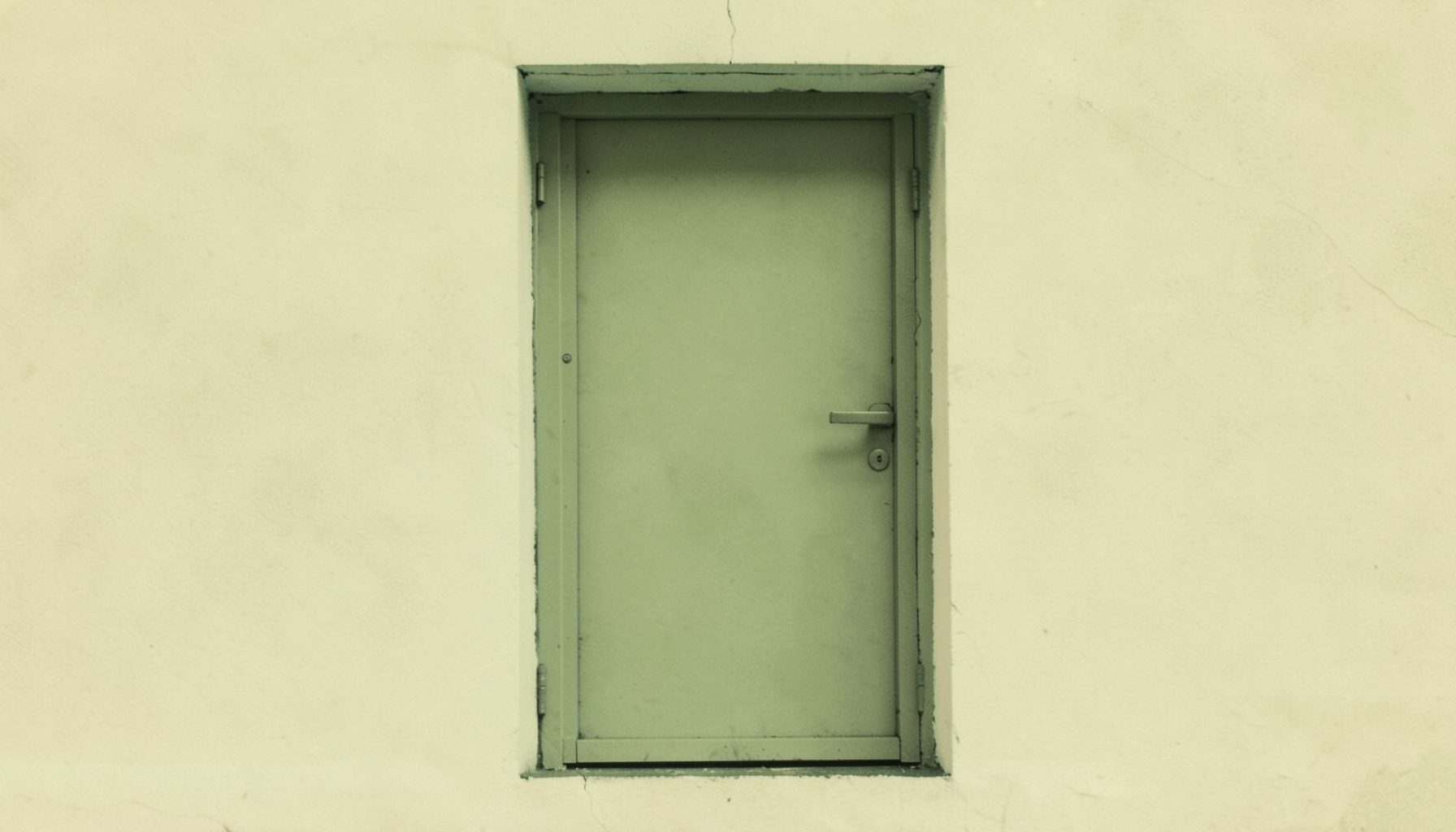 A small duotone photograph in terracotta and cream tones of a single closed door, understated and neutral